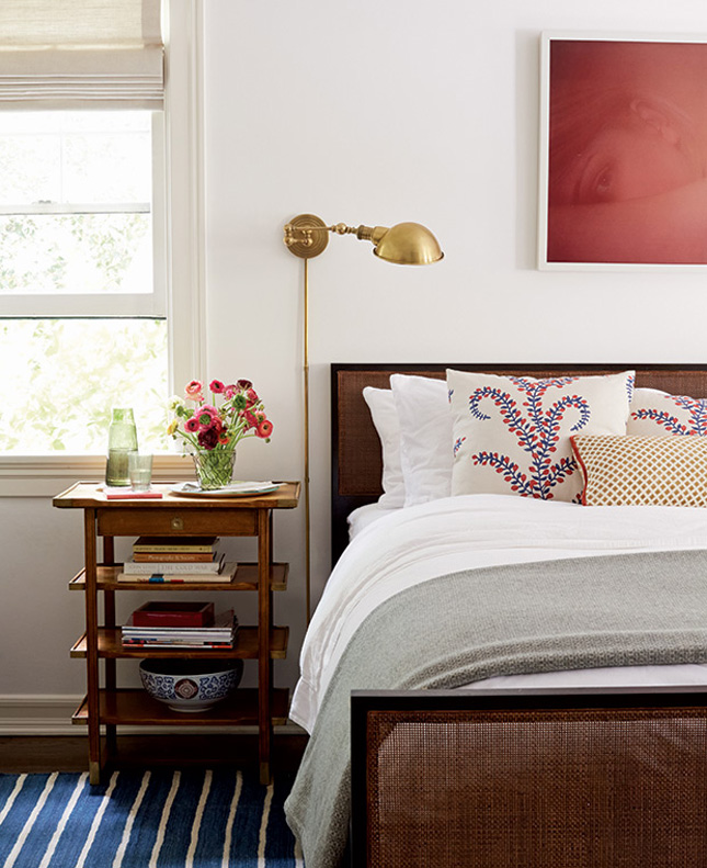 Replace bedside lamps with modern wall fittings. The red tone photo ties this space together, while the flowers and cushions add little splashes of colour.