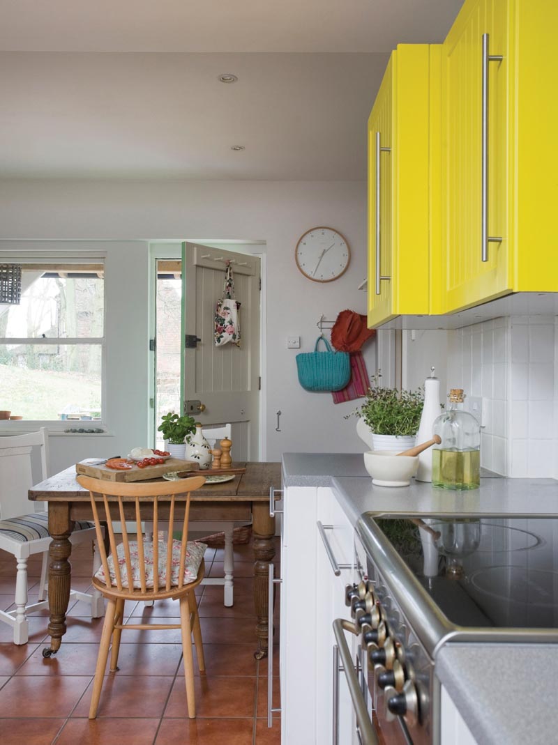 a kitchen with a pop of colour in the wall units